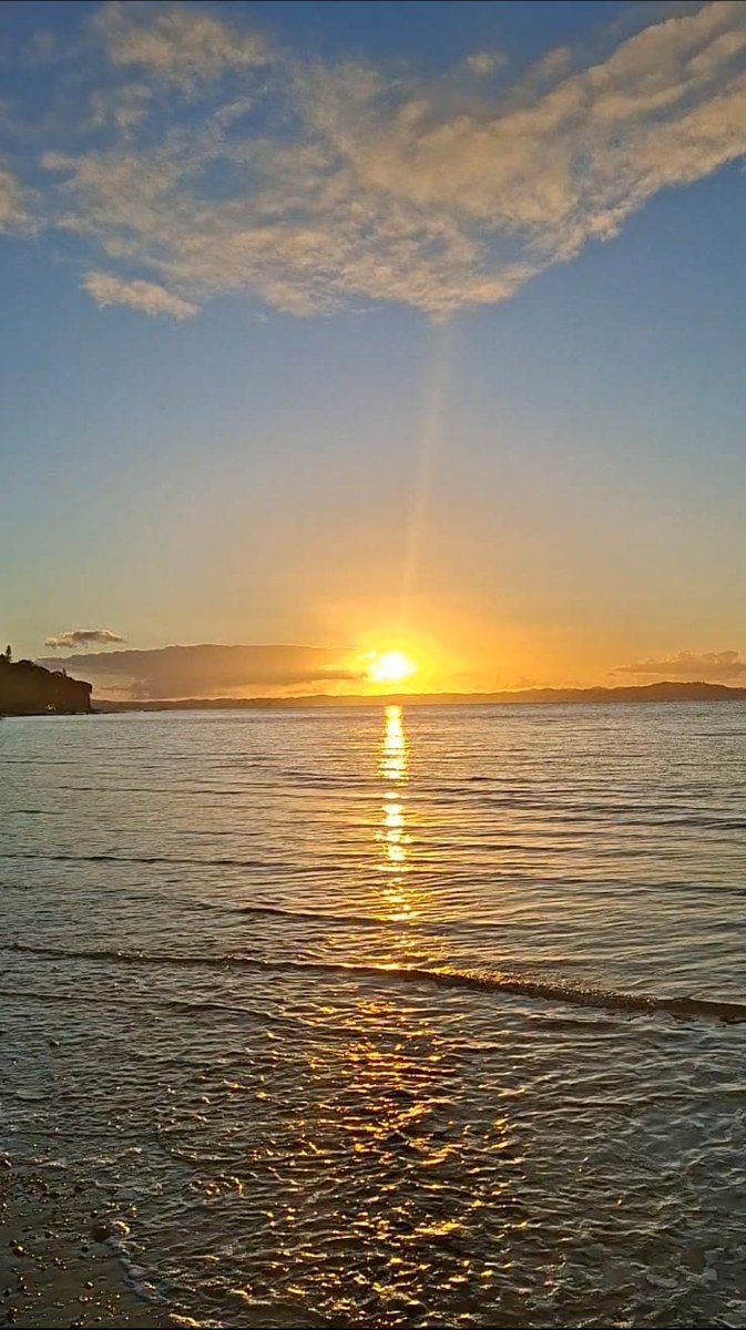 Golden sunset laying a path of light across still water